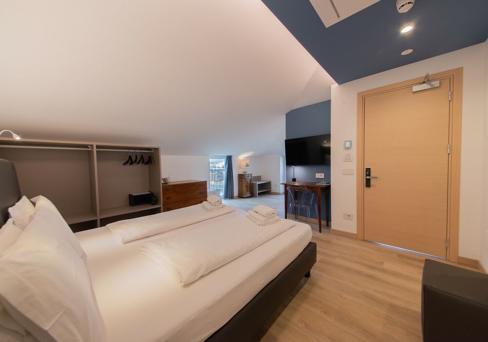Suite Familiare Deluxe | Spaziosa suite familiare con vista sulle montagne, pensata per regalare comfort e serenità a tutta la famiglia.