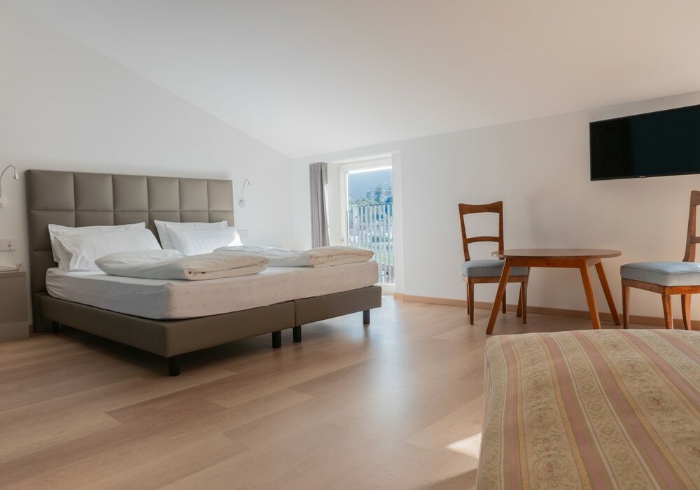 Suite Familiare Deluxe | Spaziosa suite familiare con vista sulle montagne, pensata per regalare comfort e serenità a tutta la famiglia.