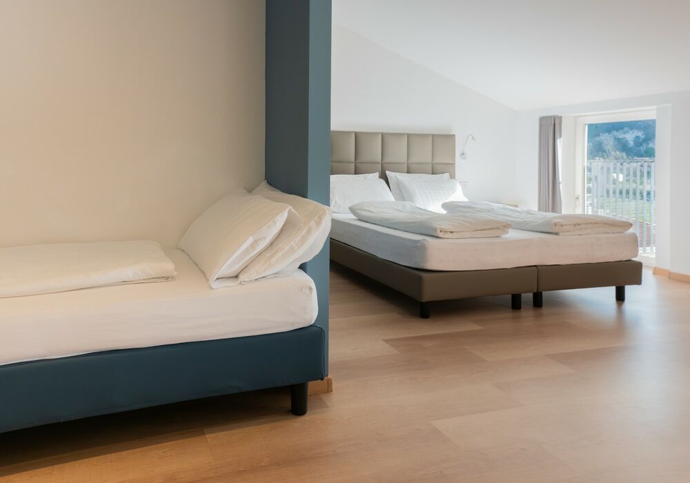 Suite Familiare Deluxe | Spaziosa suite familiare con vista sulle montagne, pensata per regalare comfort e serenità a tutta la famiglia.