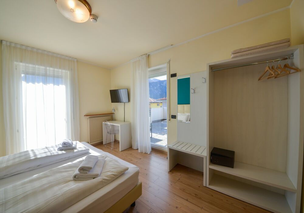 Camera Matrimoniale - Doppia con Letti Singoli con Terrazza | Una camera luminosa ed elegante con terrazza privata e vista sulle montagne, ideale per un soggiorno rilassante.