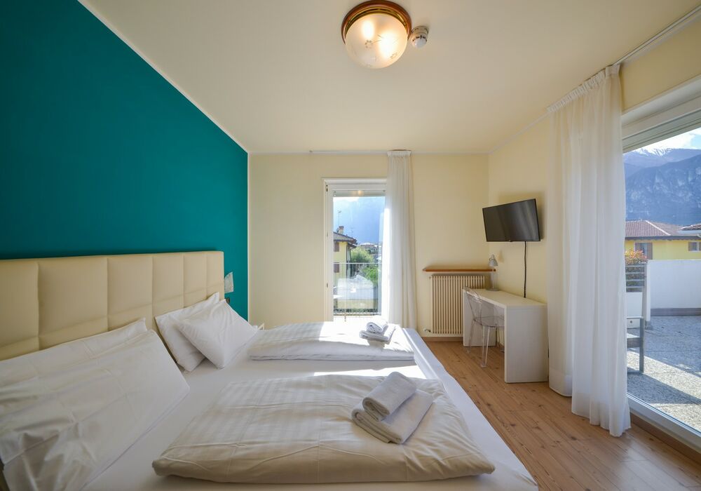 Camera Matrimoniale - Doppia con Letti Singoli con Terrazza | Una camera luminosa ed elegante con terrazza privata e vista sulle montagne, ideale per un soggiorno rilassante.