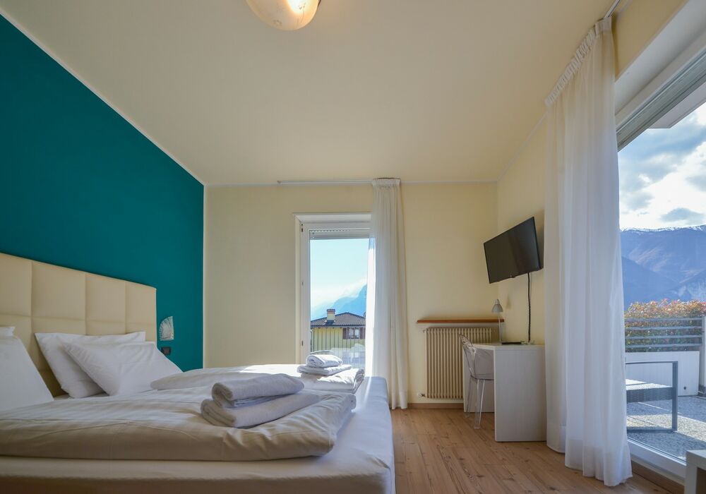 Camera Matrimoniale - Doppia con Letti Singoli con Terrazza | Una camera luminosa ed elegante con terrazza privata e vista sulle montagne, ideale per un soggiorno rilassante.