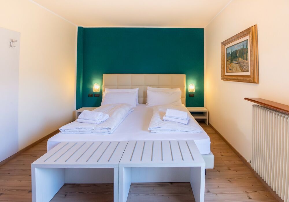 Camera Matrimoniale - Doppia con Letti Singoli con Terrazza | Una camera luminosa ed elegante con terrazza privata e vista sulle montagne, ideale per un soggiorno rilassante.