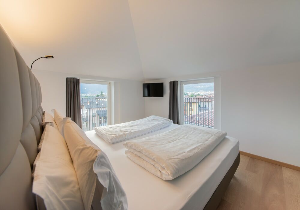 Junior Suite con balcone | Una spaziosa suite mansardata con più privacy e una vista aperta sulle montagne per un soggiorno di autentico relax.