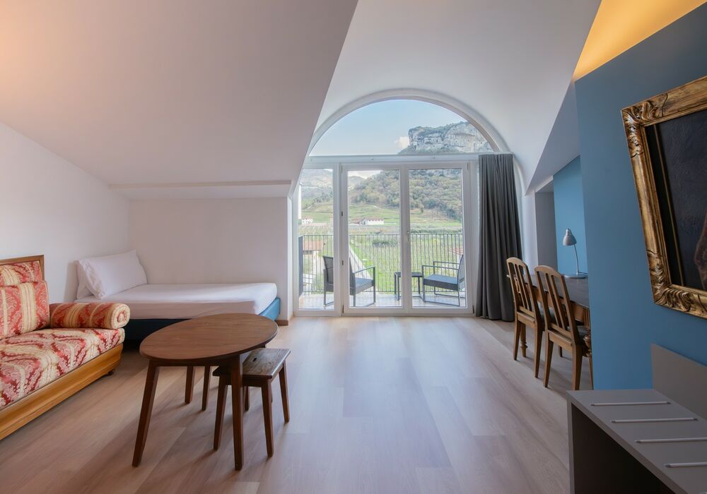 Junior Suite con balcone | Una spaziosa suite mansardata con più privacy e una vista aperta sulle montagne per un soggiorno di autentico relax.