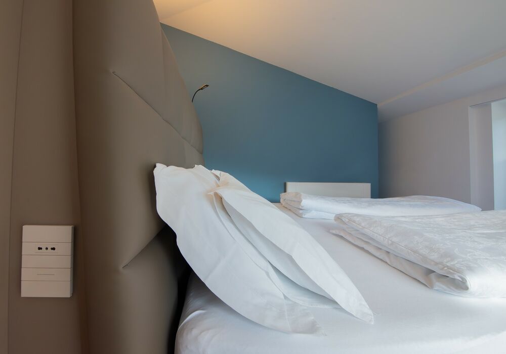 Junior Suite con balcone | Una spaziosa suite mansardata con più privacy e una vista aperta sulle montagne per un soggiorno di autentico relax.