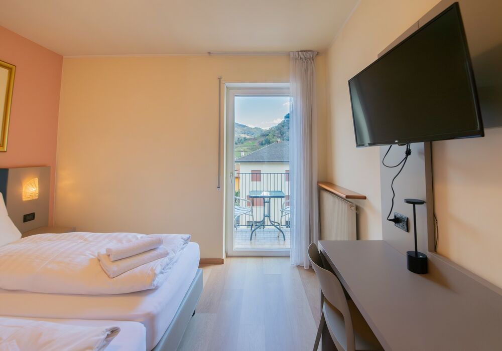 Camera Matrimoniale/Doppia con Letti Singoli | Spazi luminosi, balcone e vista montagna per un soggiorno all’insegna del comfort.