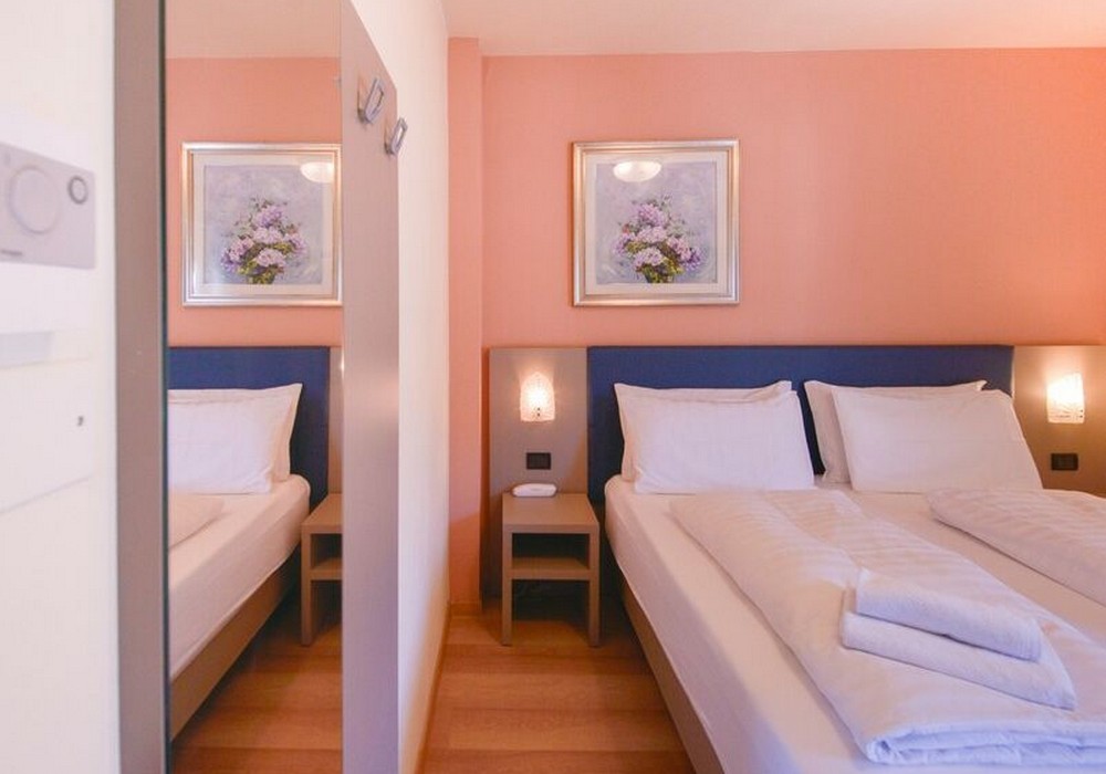 Camera Matrimoniale/Doppia con Letti Singoli | Spazi luminosi, balcone e vista montagna per un soggiorno all’insegna del comfort.