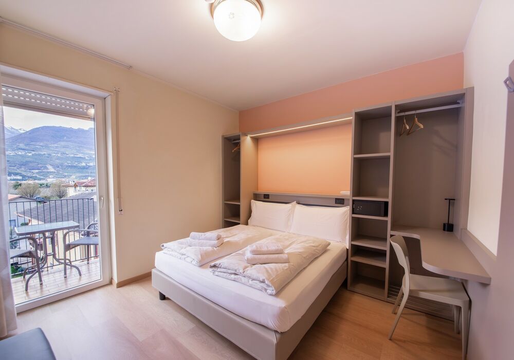 Camera Matrimoniale/Doppia con Letti Singoli | Spazi luminosi, balcone e vista montagna per un soggiorno all’insegna del comfort.